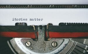 pexels-photo-1995842-1995842 Close-up of a vintage typewriter with the text 'Stories matter' typed on paper, evoking nostalgia.